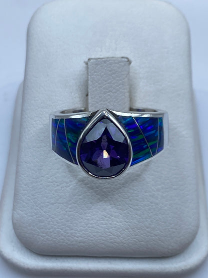 Anillo solitario de plata con ópalo de fuego azul sobre fondo blanco