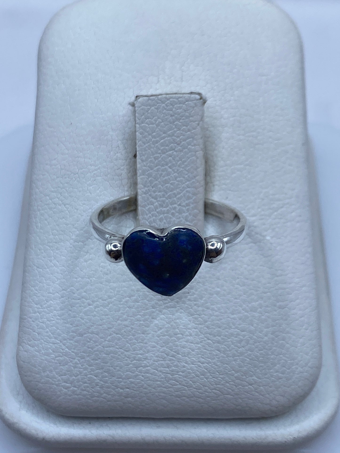 Anillo de plata .950 con solitario de lapislázuli azul profundo sobre joyero blanco