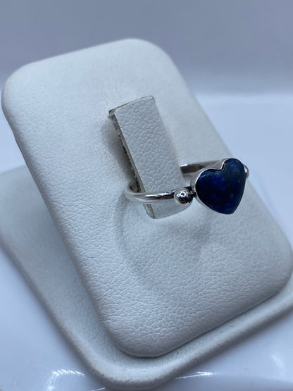 Vista lateral del anillo minimalista con esferas de plata a los lados del lapislázuli