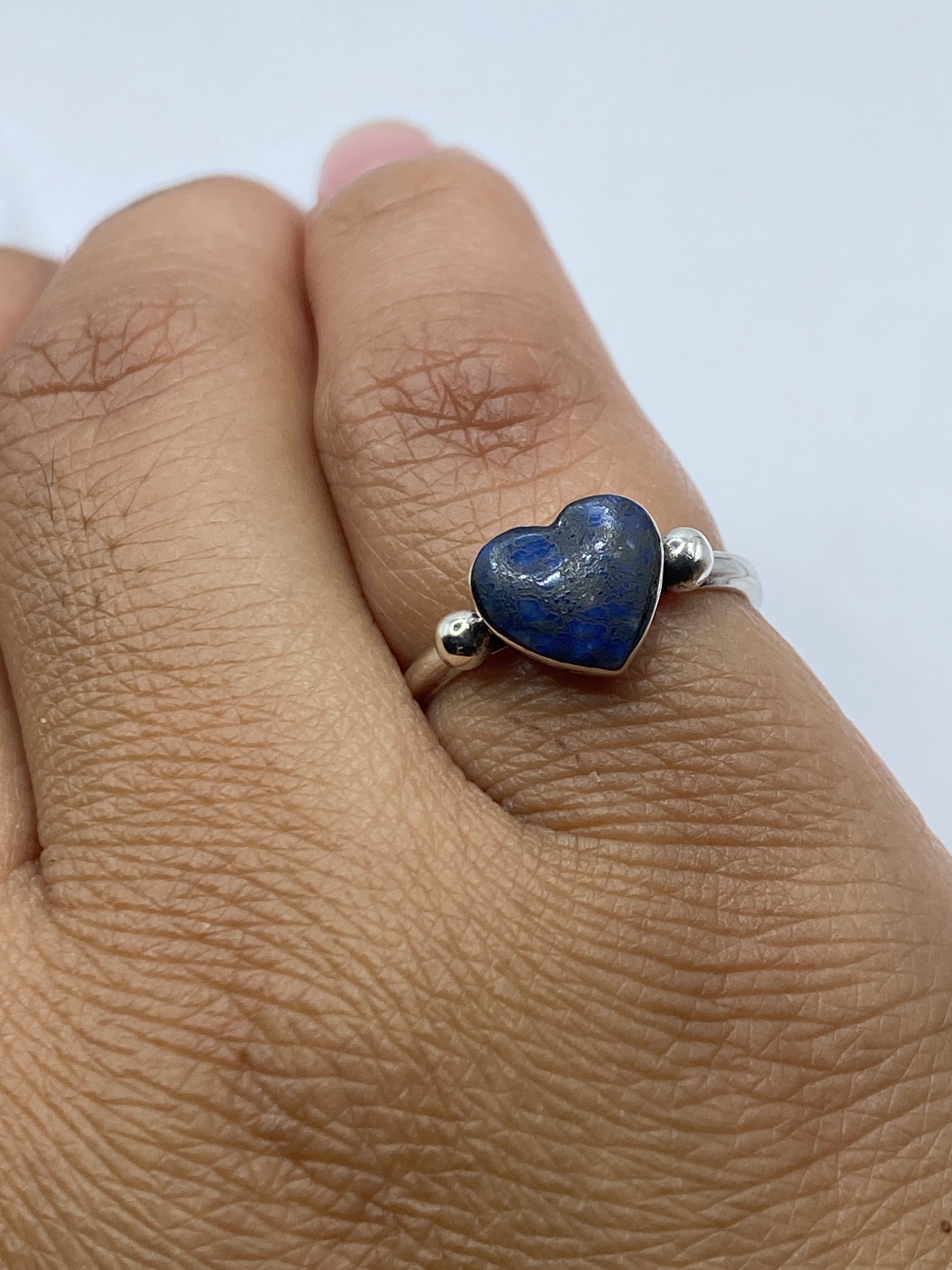 Anillo de lapislázuli en dedo de mujer mostrando el color y brillo de la piedra natural