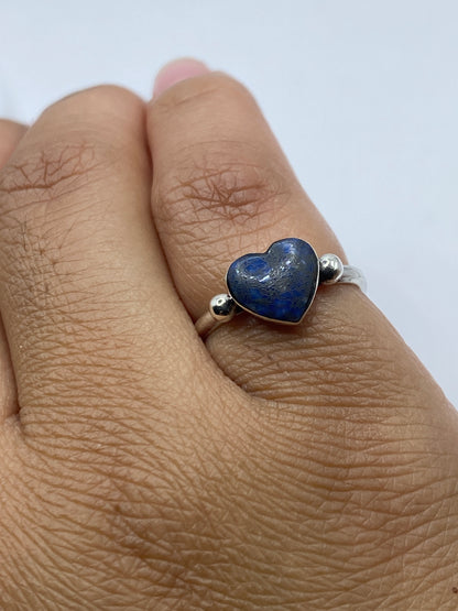 Anillo de lapislázuli en dedo de mujer mostrando el color y brillo de la piedra natural