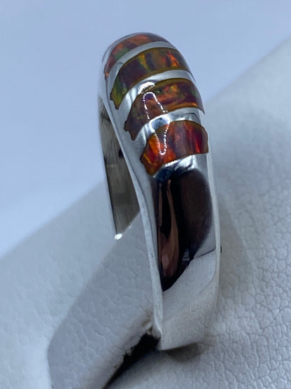 Anillo en la mano de una mujer con ópalo de fuego brillando
