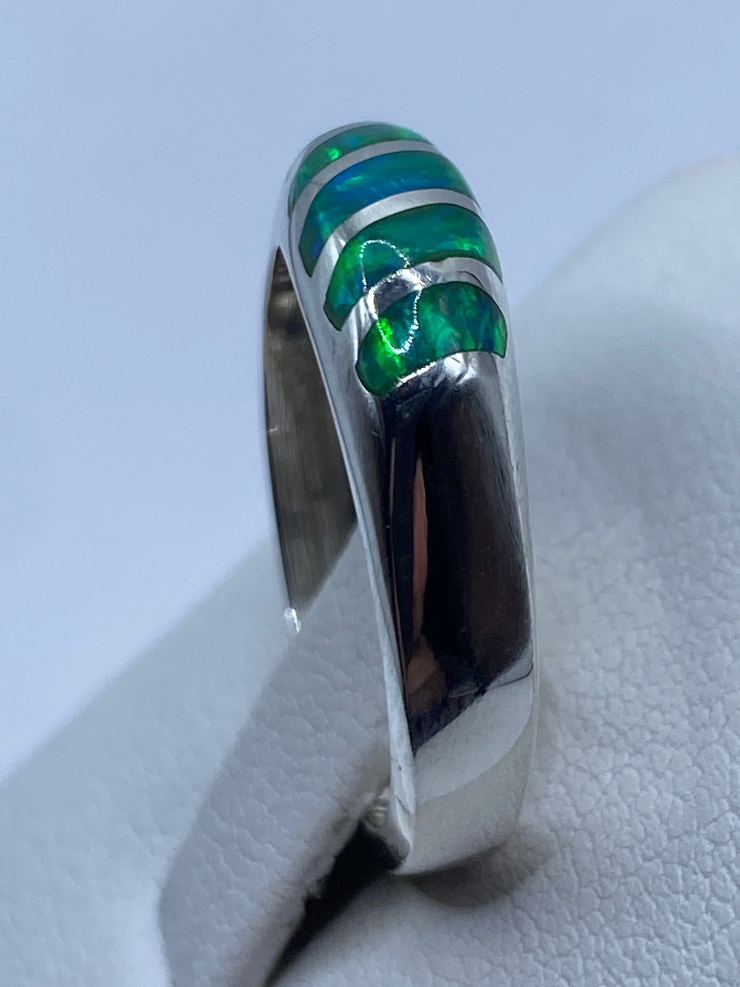 Anillo en dedo mostrando el engaste a mano del ópalo de fuego