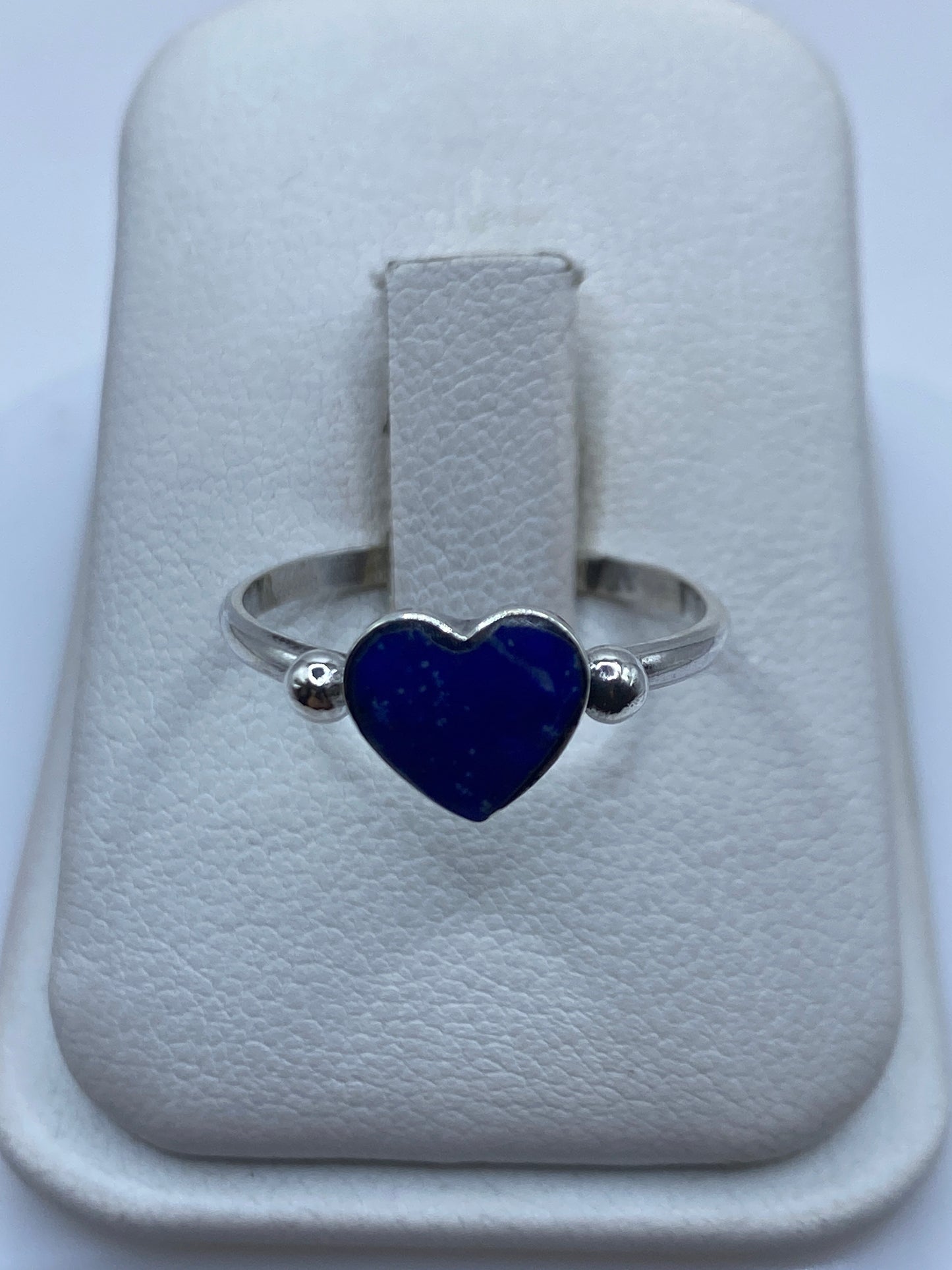 Anillo solitario de plata .925 con piedra azul en engaste bezel, visto de frente