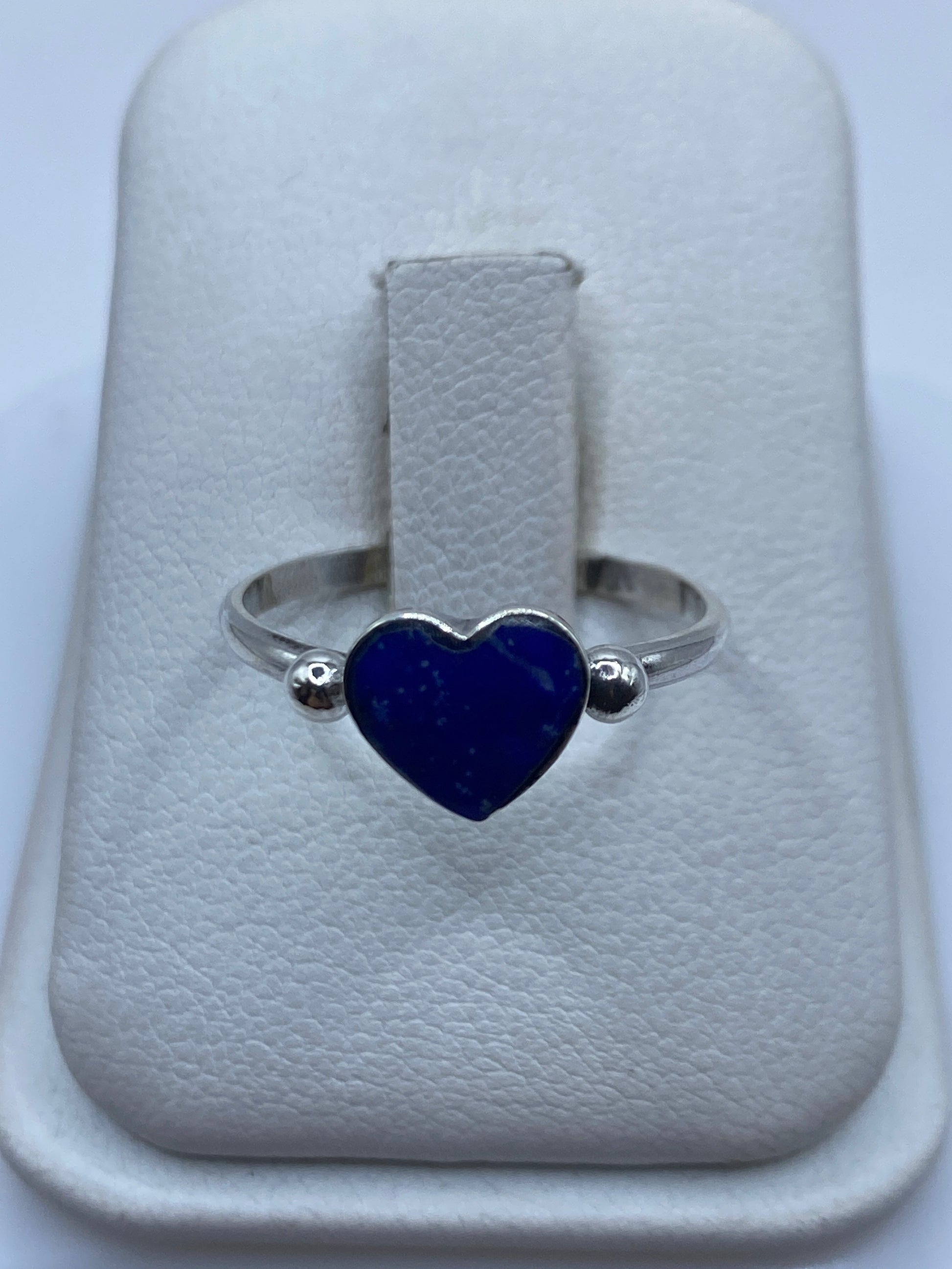 Anillo solitario de plata .925 con piedra azul en engaste bezel, visto de frente