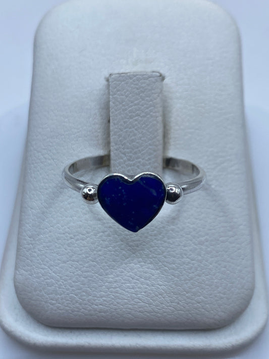 Anillo solitario de plata .925 con piedra azul en engaste bezel, visto de frente