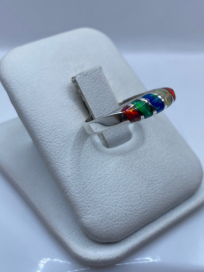 Vista lateral del anillo unisex en plata .950 mostrando el juego de colores del ópalo