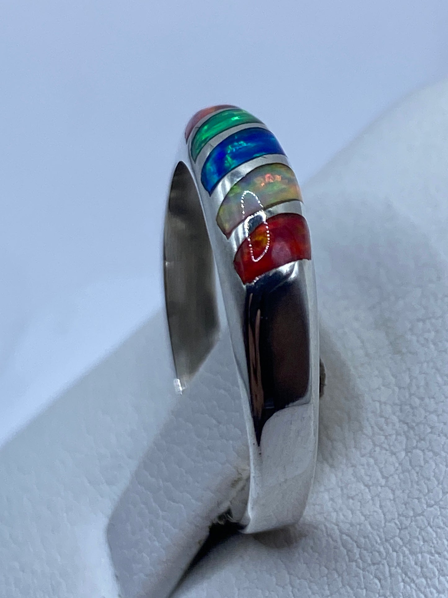 Detalle del ópalo de fuego con tonos rojos, verdes y azules en el engaste de plata