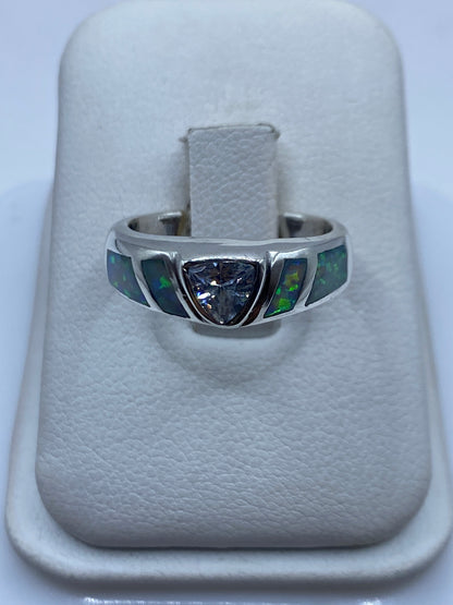 Anillo de plata banda ancha con ópalo de fuego natural mostrando destellos verdes en la mano