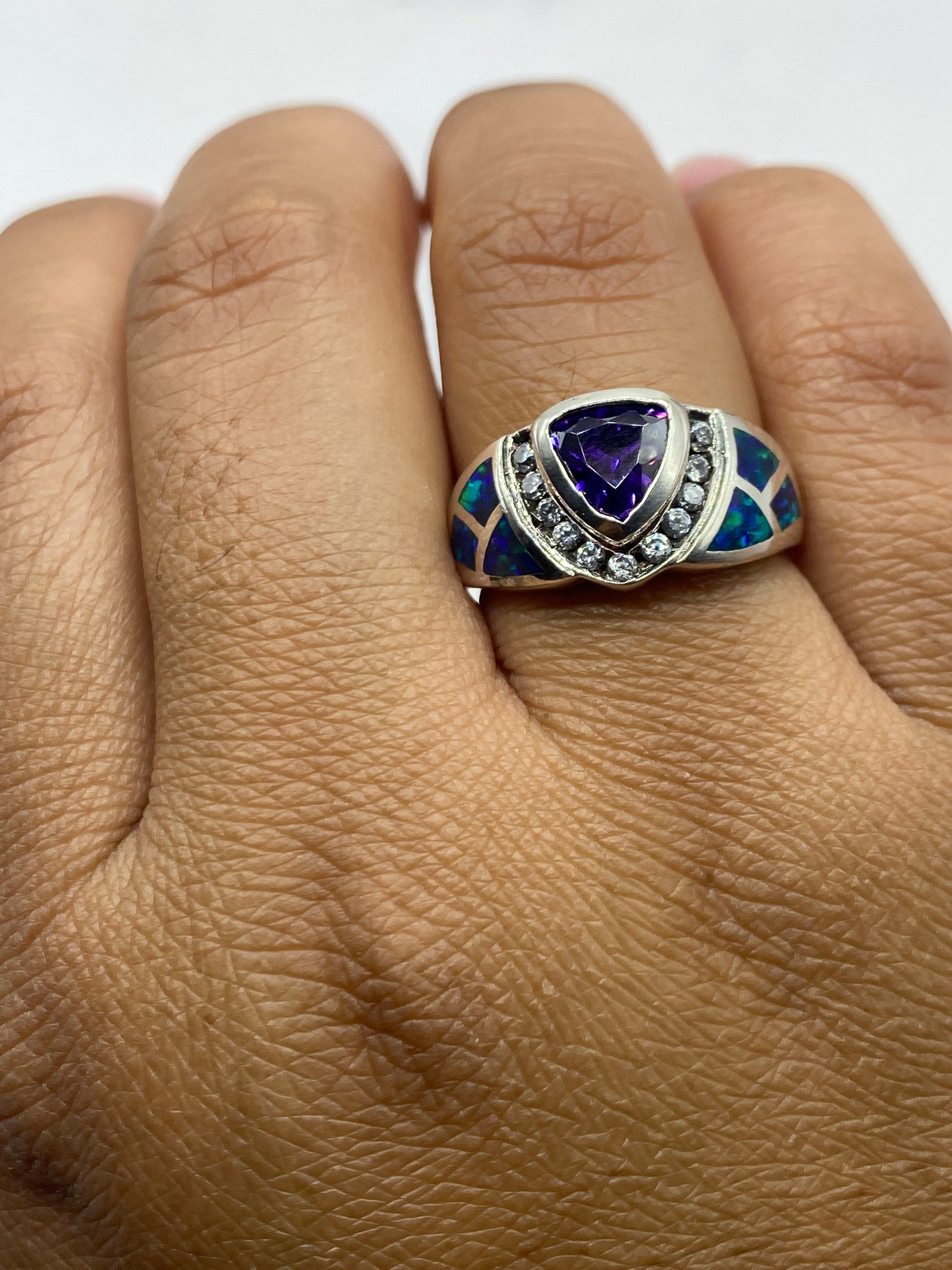 Anillo en dedo mostrando el juego de luz del ópalo de fuego bajo iluminación natural