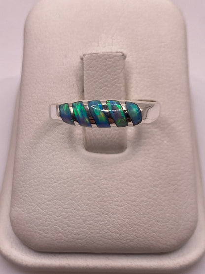 Anillo de plata .950 con ópalo de fuego azul cielo, banda minimalista, sosteniendo la piedra