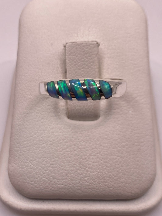 Anillo de plata .950 con ópalo de fuego azul cielo, banda minimalista, sosteniendo la piedra