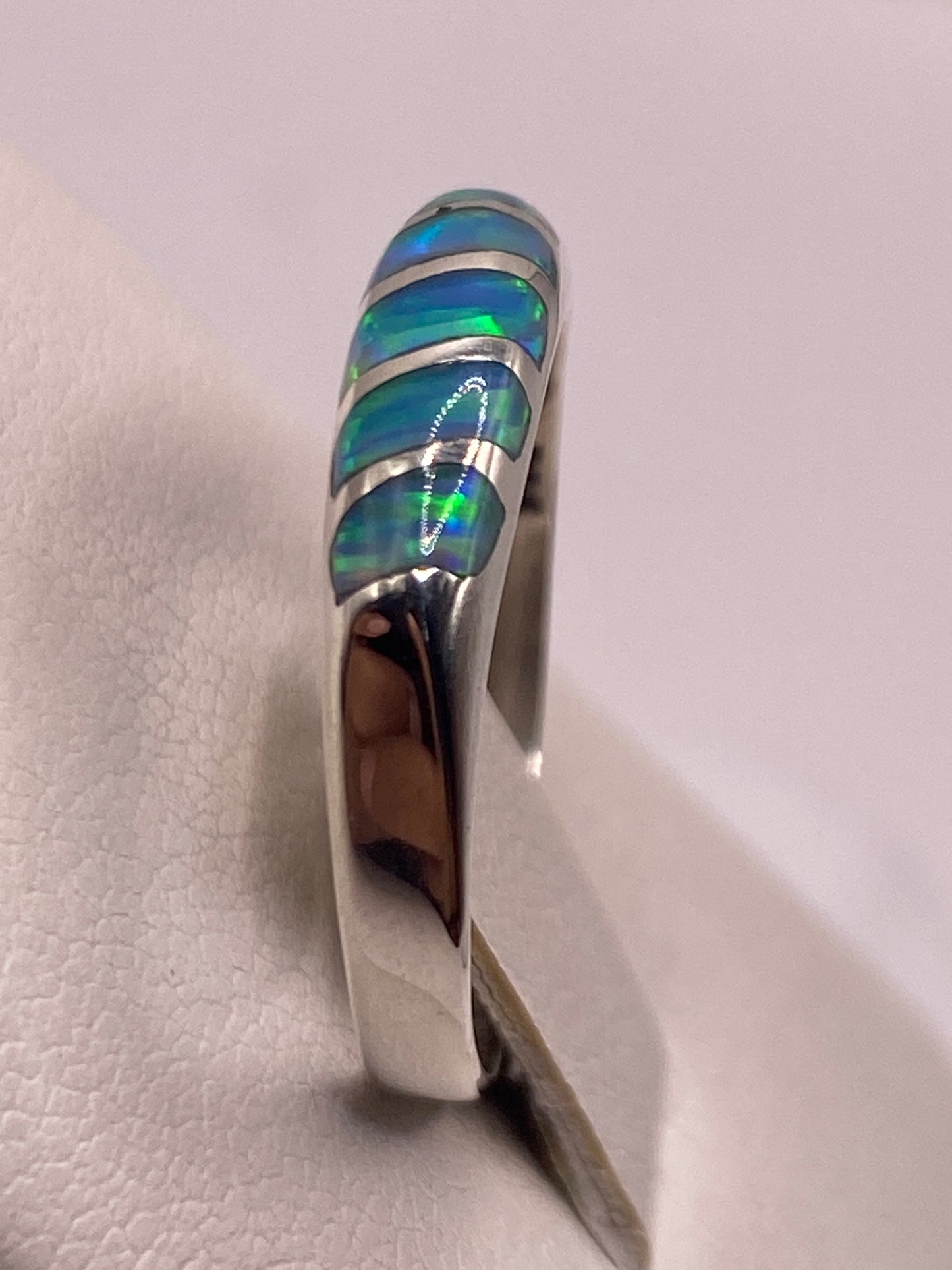 Anillo en mano de mujer, revelando cómo la piedra cambia de color según el ángulo