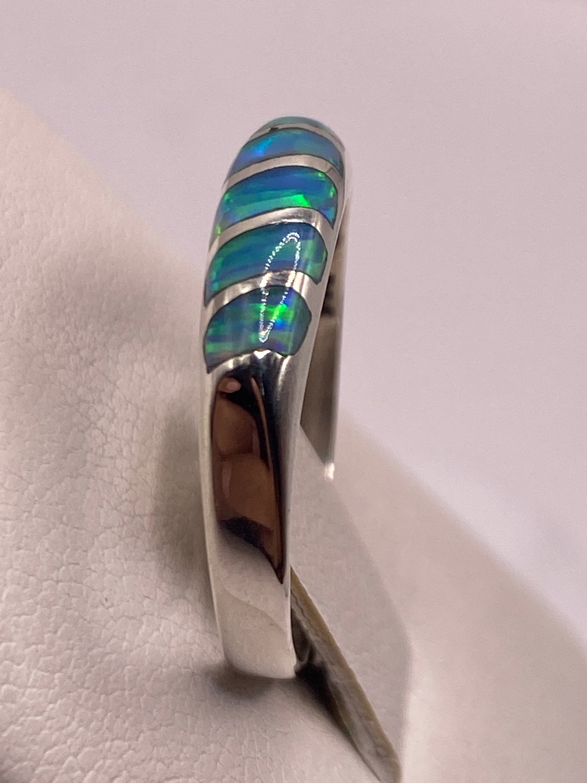 Anillo en mano de mujer, revelando cómo la piedra cambia de color según el ángulo
