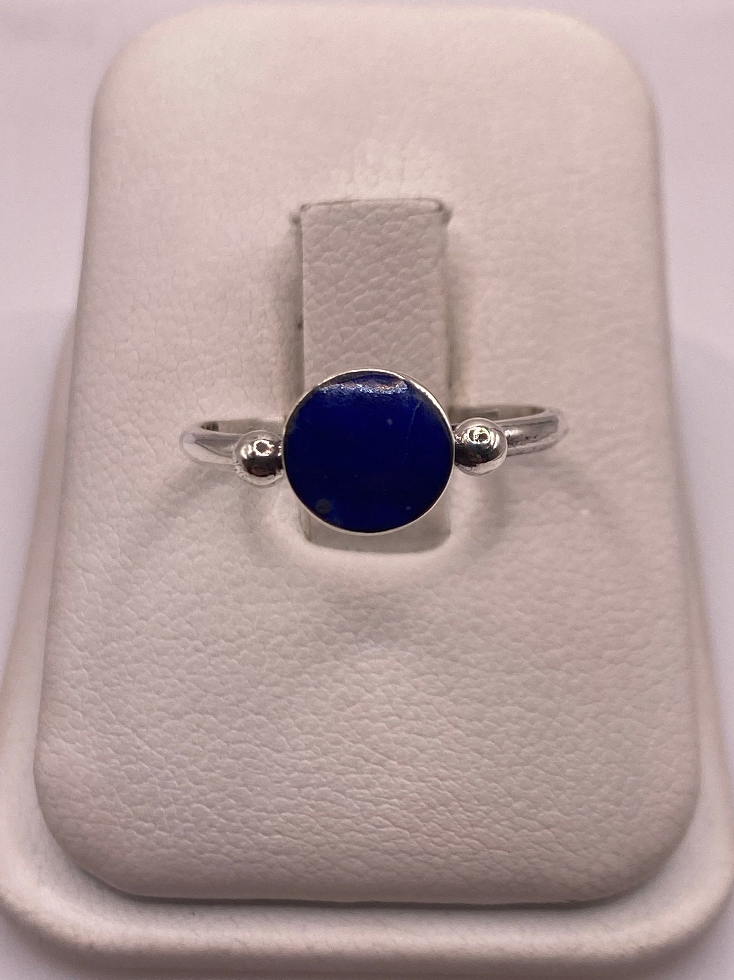 Anillo de plata .950 con lapislázuli azul en la mano de una mujer
