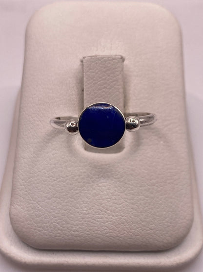 Anillo de plata .950 con lapislázuli azul en la mano de una mujer