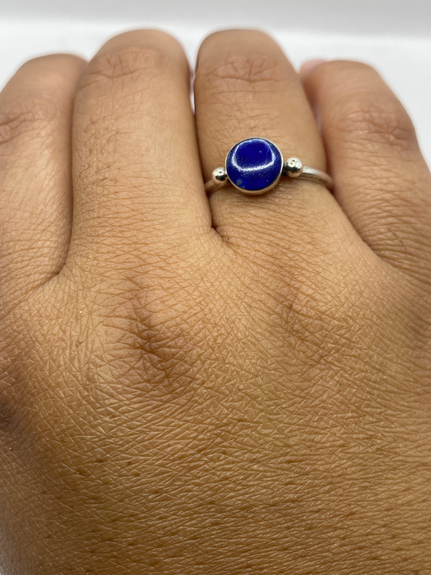Anillo solitario sobre fondo gris mostrando el sello 950