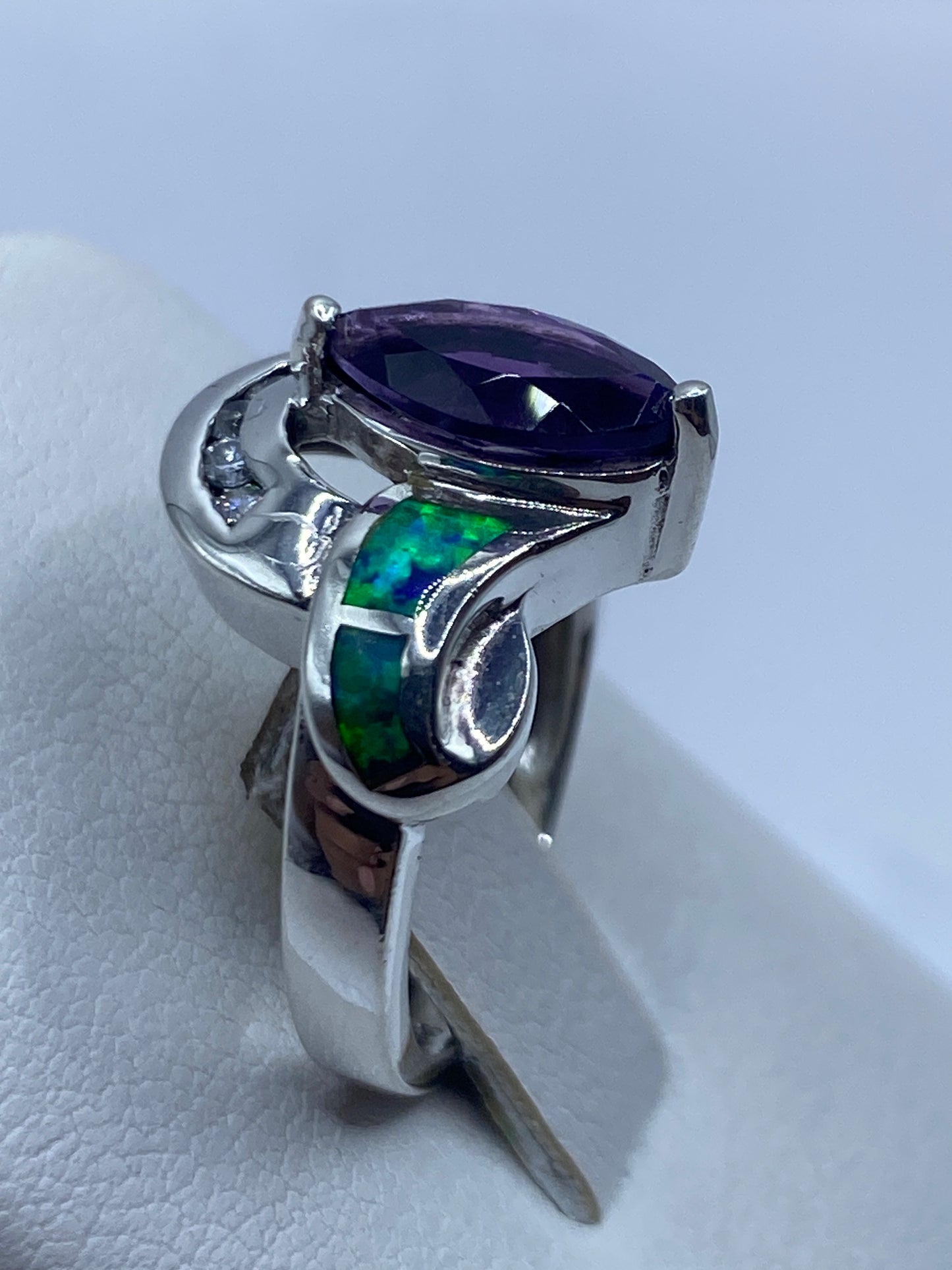 Anillo escultural con ópalo en la mano mostrando juego de colores