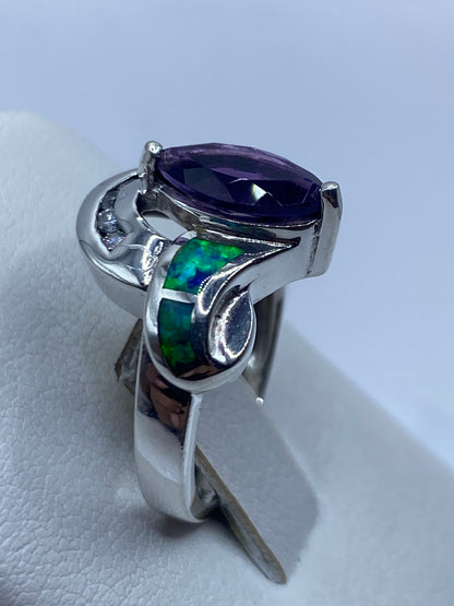 Anillo escultural con ópalo en la mano mostrando juego de colores