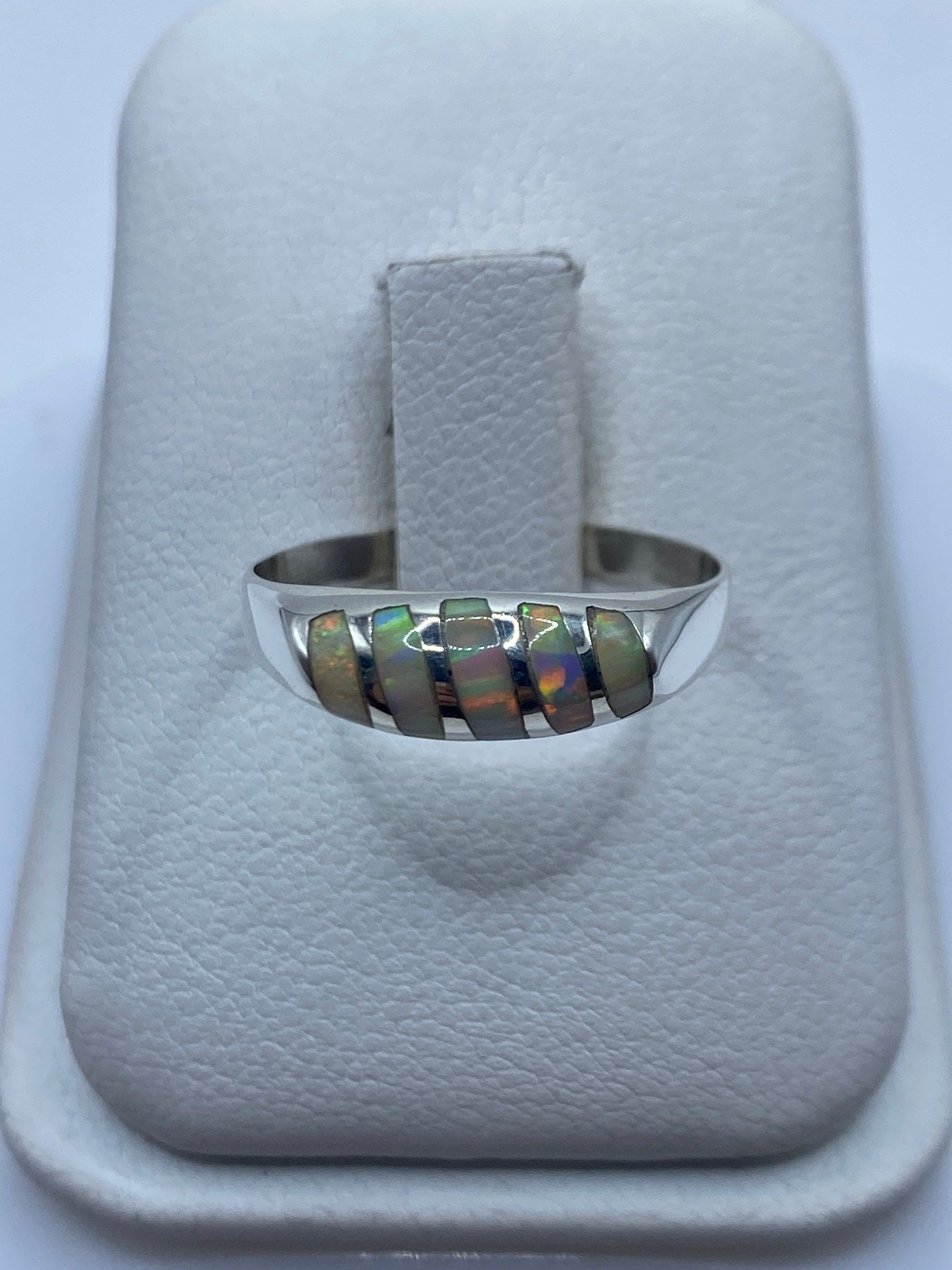 Anillo de plata con ópalo de fuego natural mostrando fuego multicolor en banda minimalista