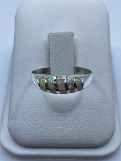 Anillo de plata con ópalo de fuego natural mostrando fuego multicolor en banda minimalista