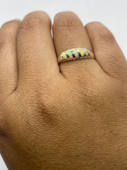 Anillo minimalista en mano mostrando el brillo natural y fuego del ópalo de fuego