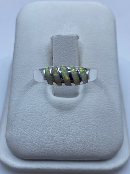 Anillo de plata .950 con ópalo de fuego natural en tono verde y naranja, mostrado en estuche blanco