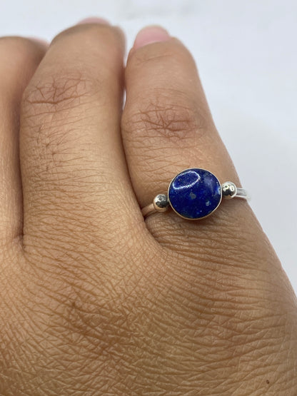 Anillo solitario sobre dedo mostrando el color profundo del lapislázuli y pulido de la plata