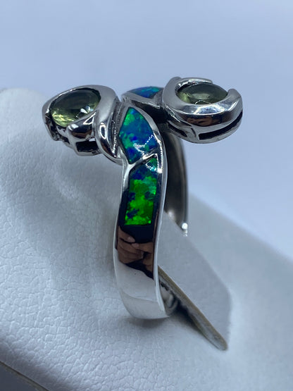 Detalle del ópalo de fuego con destellos azules y verdes en la mano