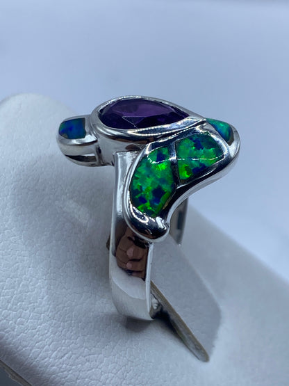 Anillo en mano mostrando los destellos verdes y azules del ópalo de fuego