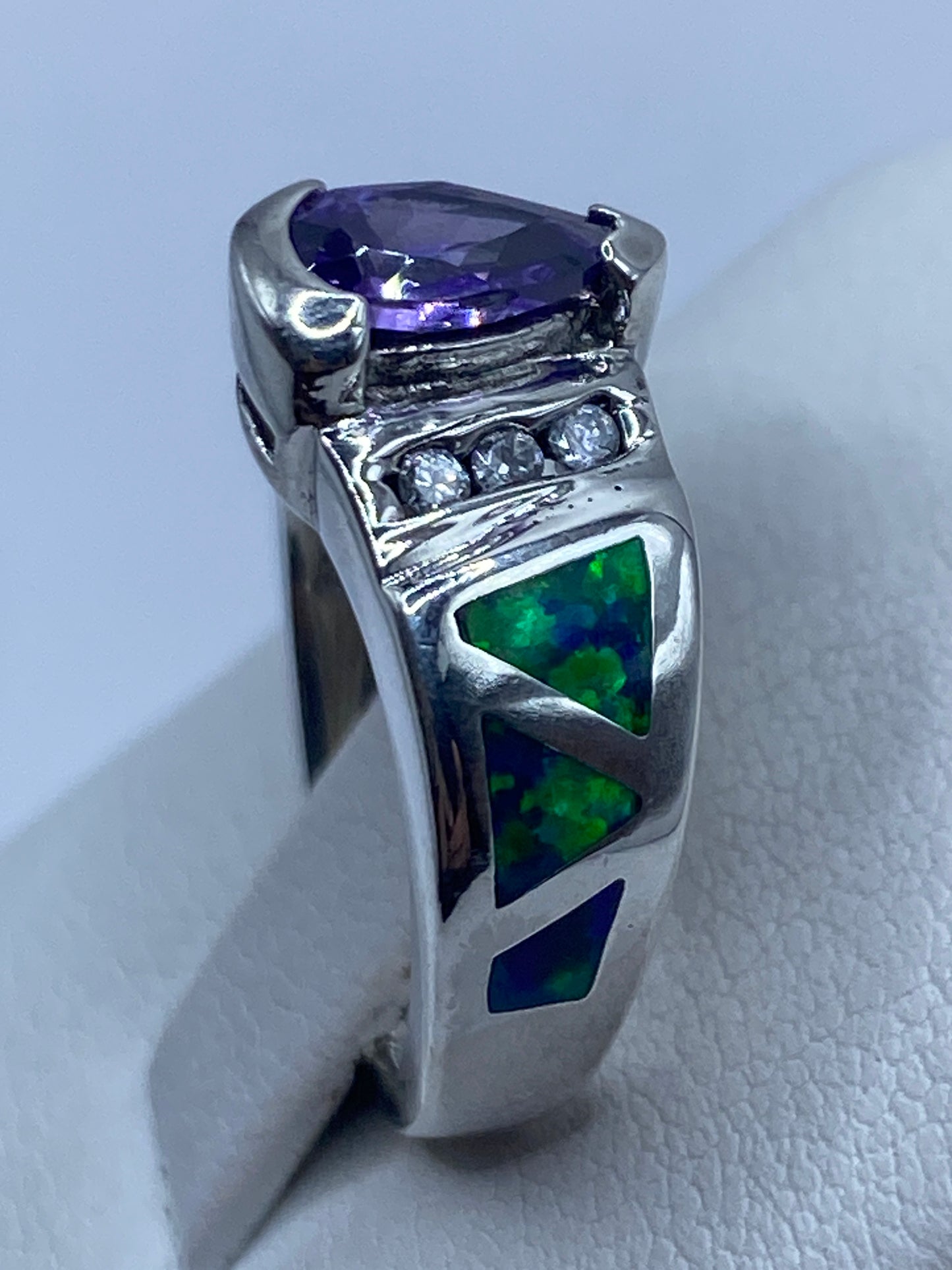 Anillo asimétrico de plata en la mano de una mujer, brillando con luz natural
