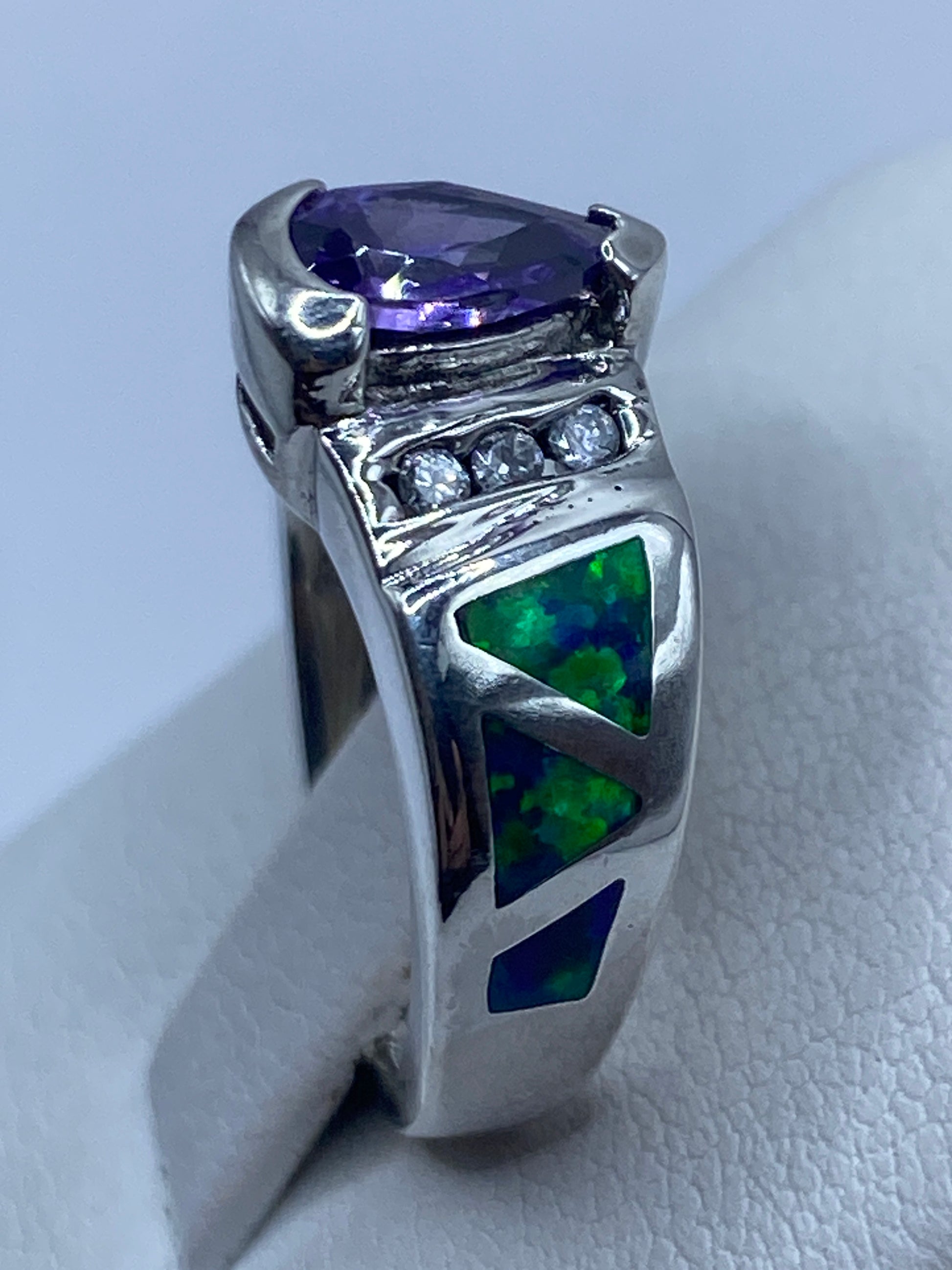 Anillo asimétrico de plata en la mano de una mujer, brillando con luz natural