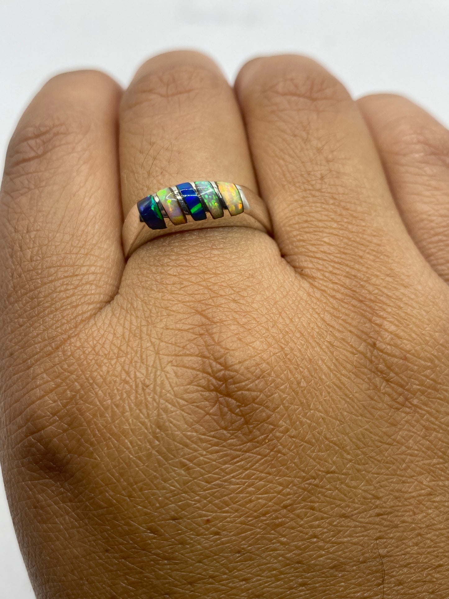 Anillo ópalo de fuego sobre fondo neutro mostrando el sello 950 de pureza de plata