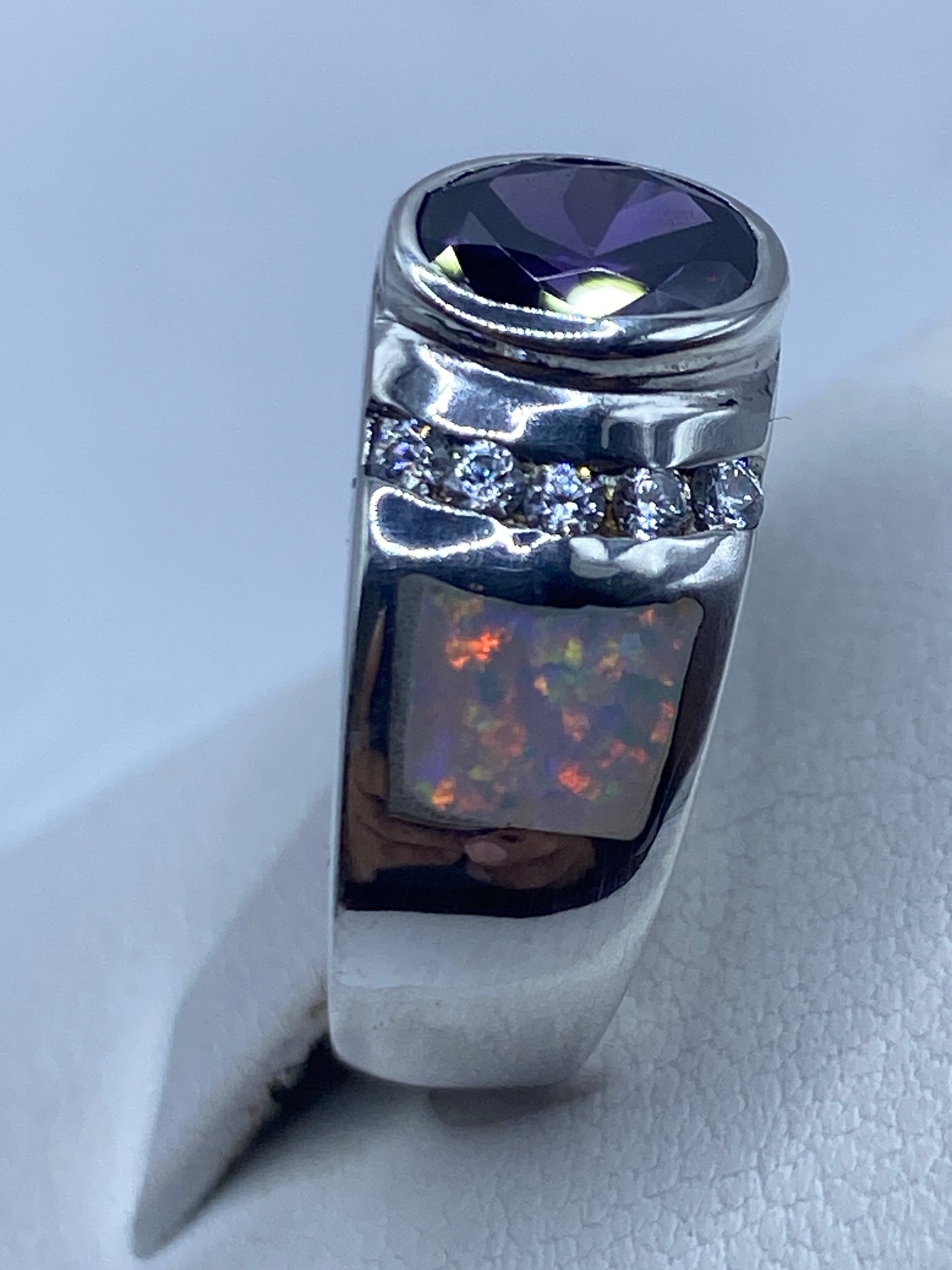 Anillo de plata artesanal en la mano de una mujer resaltando el brillo del ópalo