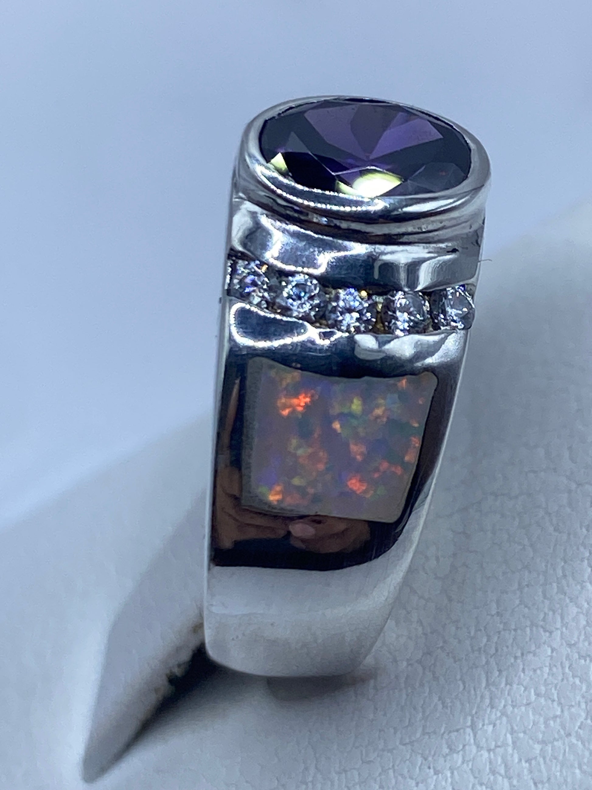 Anillo de plata artesanal en la mano de una mujer resaltando el brillo del ópalo