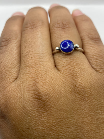Anillo de plata lapislázuli en la mano mostrando el solitario minimalista