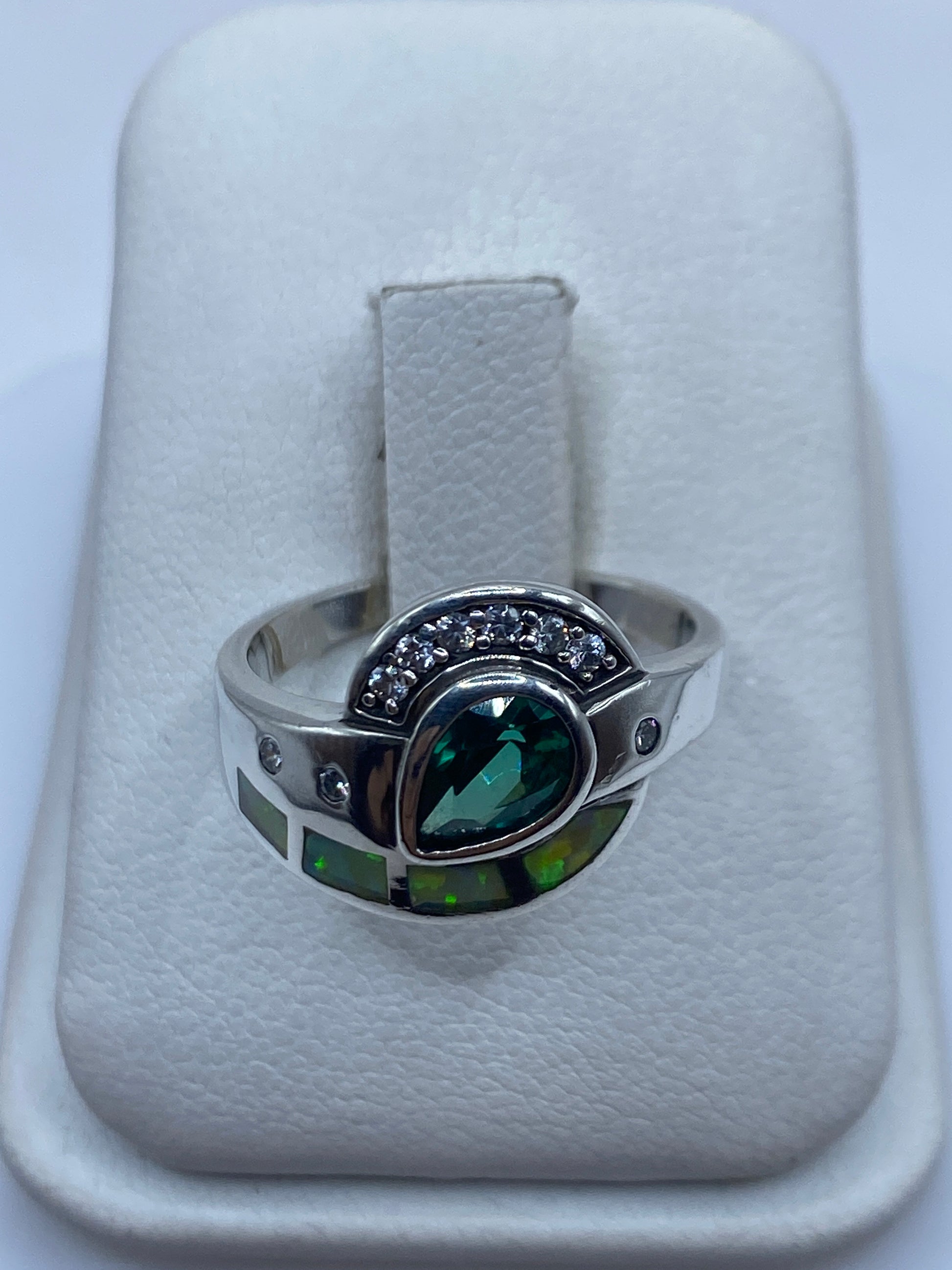 Anillo de plata con ópalo de fuego verde limón engastado, vista frontal sobre fondo blanco