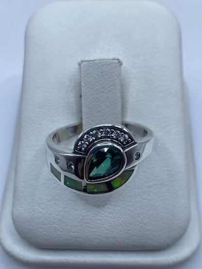 Anillo de plata con ópalo de fuego verde limón engastado, vista frontal sobre fondo blanco