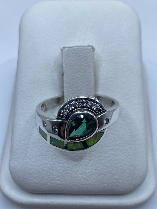 Anillo de plata con ópalo de fuego verde limón engastado, vista frontal sobre fondo blanco