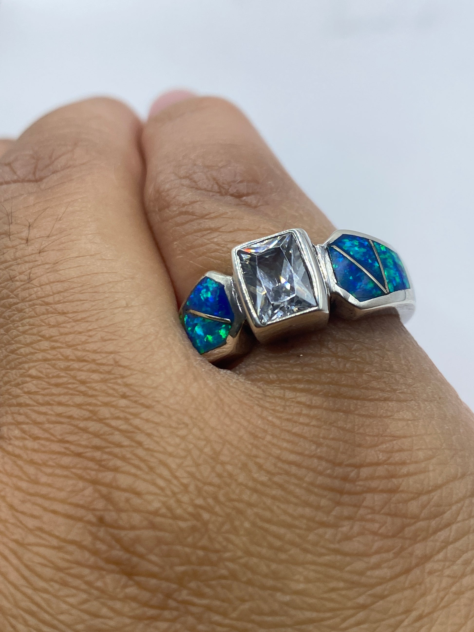 Anillo en la mano mostrando el sello 925 y el efecto luminoso del ópalo azul