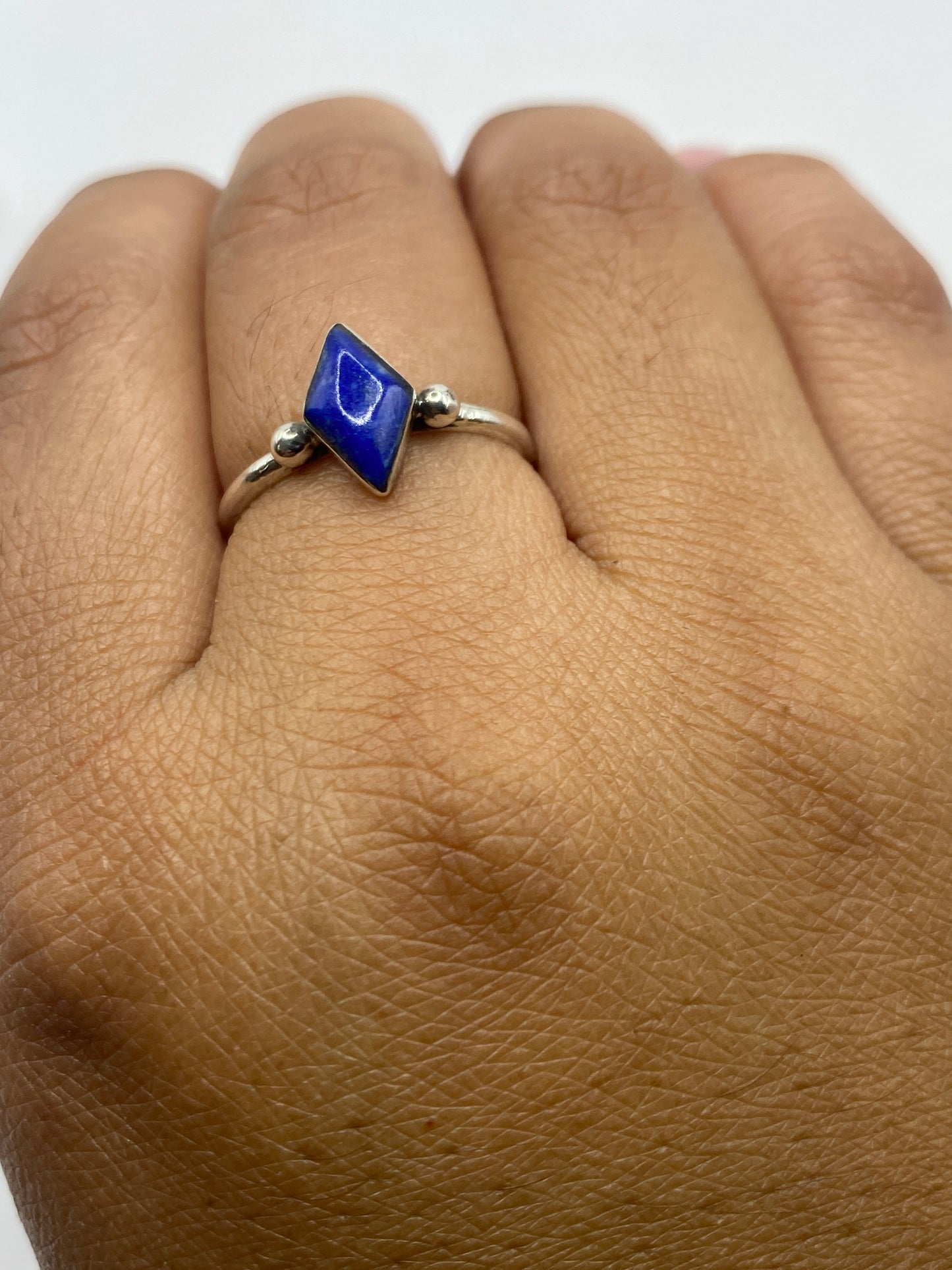Anillo en dedo mostrando el color azul profundo de la piedra