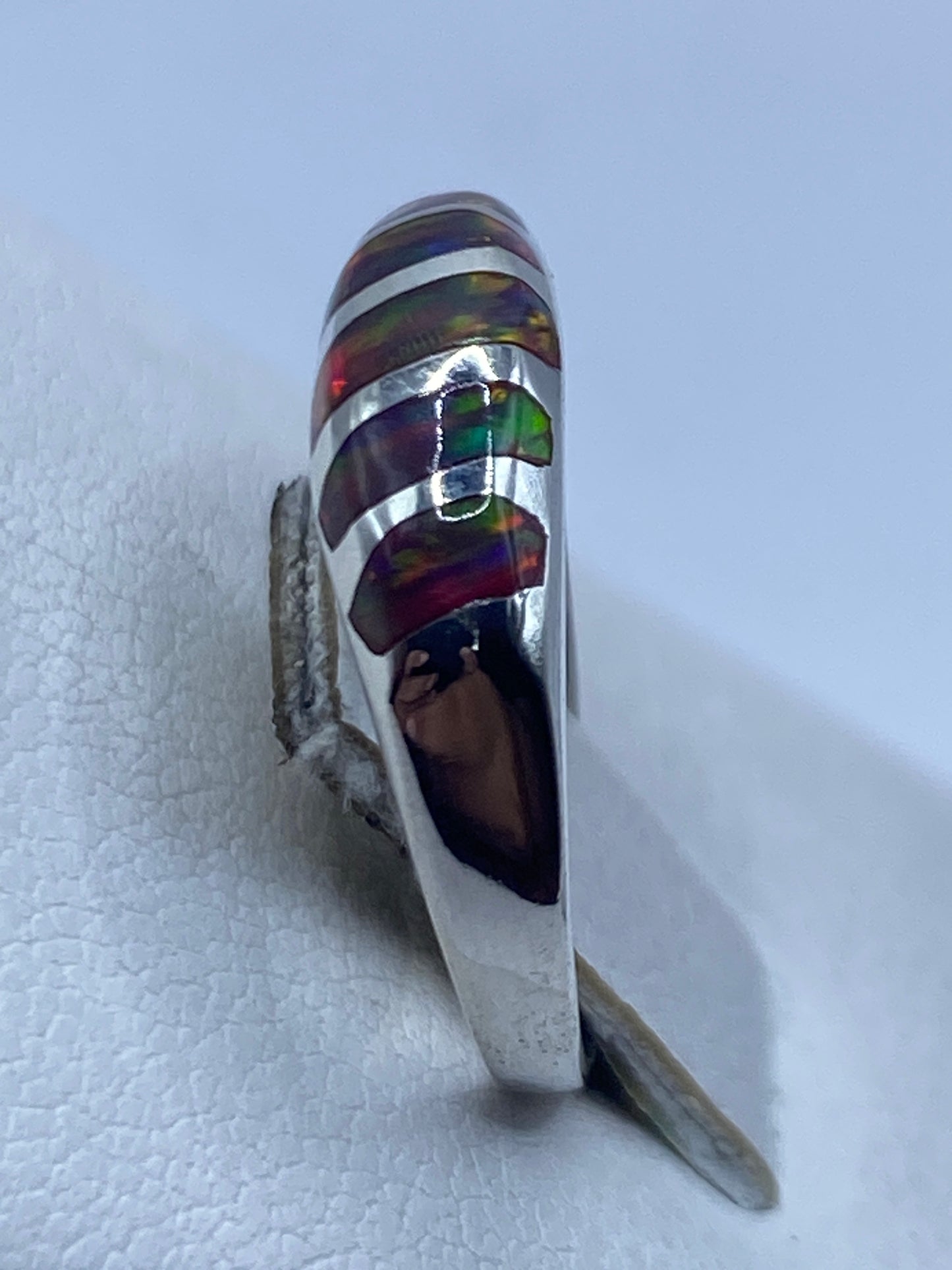 Anillo en la mano mostrando los colores naturales del ópalo de fuego