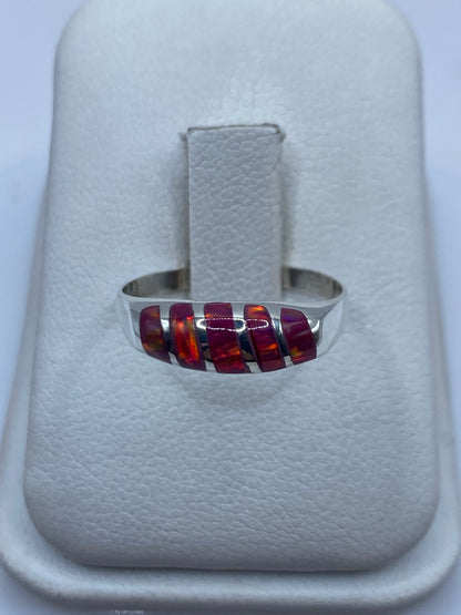 Anillo de plata .950 con ópalo de fuego rosa mostrando juego de colores naranja y dorado
