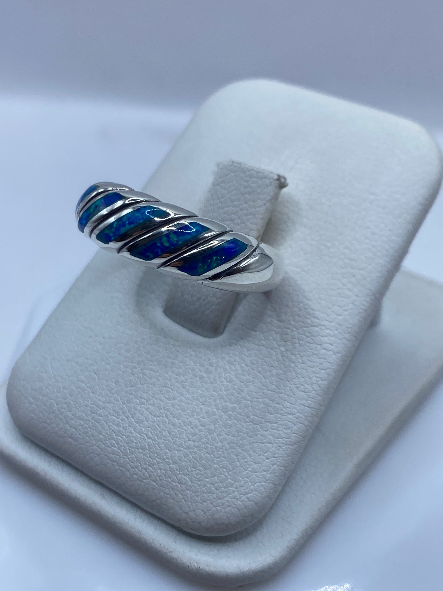 Vista frontal del anillo unisex mostrando juego de color azul y verde del ópalo