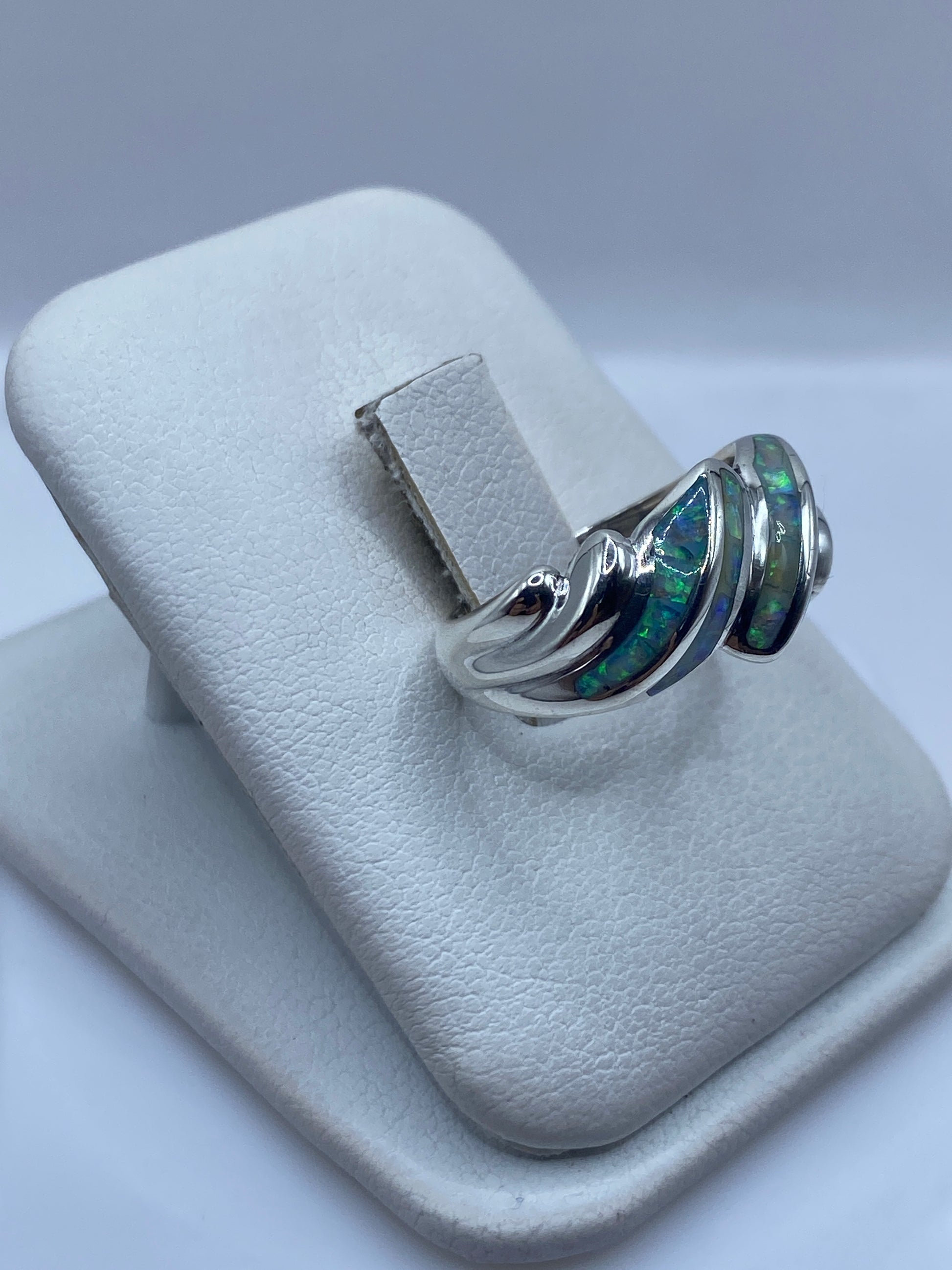 Detalle frontal del anillo ondulado mostrando el juego de color del ópalo