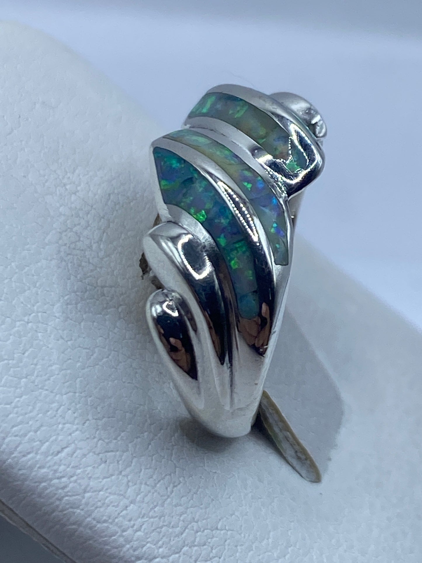 Vista lateral del anillo fluido en plata .950 con piedra iridiscente
