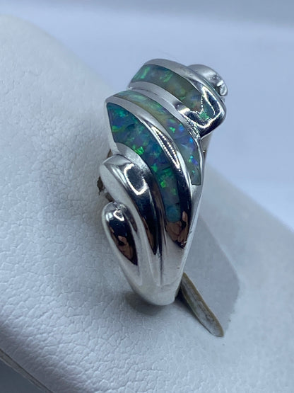 Vista lateral del anillo fluido en plata .950 con piedra iridiscente