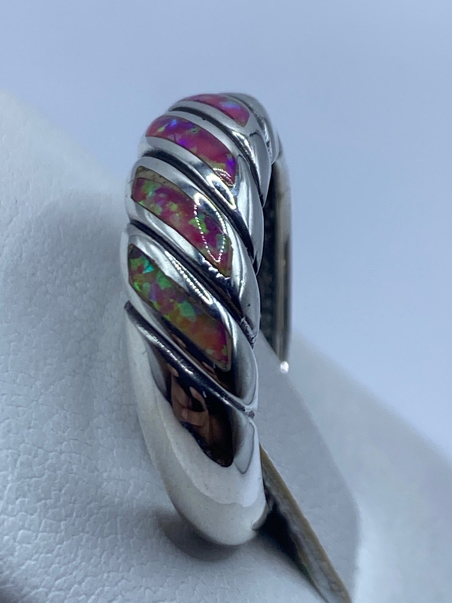 Detalle del ópalo de fuego con destellos rosa, verde y multicolor bajo luz natural