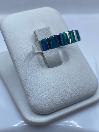 Detalle frontal del ópalo de fuego mostrando juego de colores azul y verde en plata .925