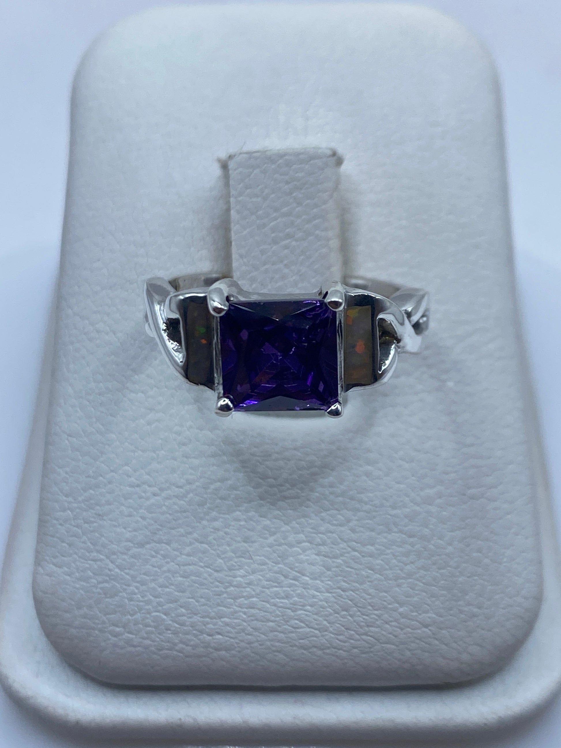 Anillo de plata con ópalo de fuego natural multicolor en la mano de una mujer